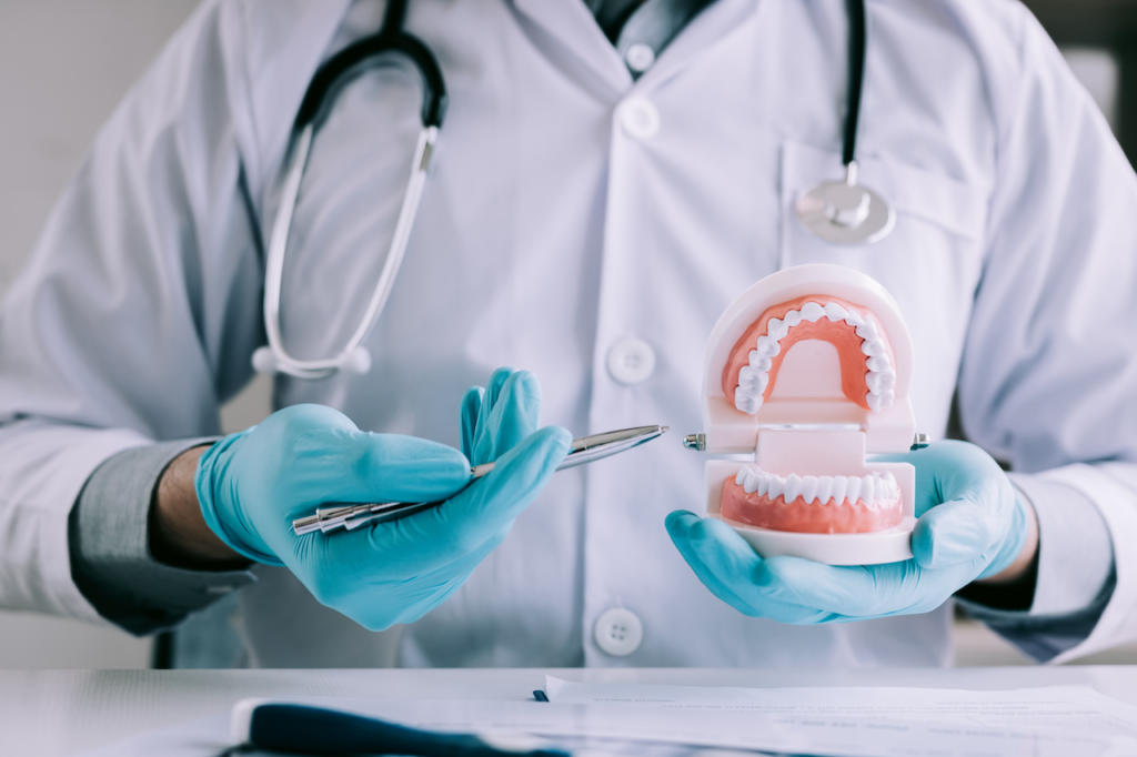 Dental technician examining a set of dental implants.